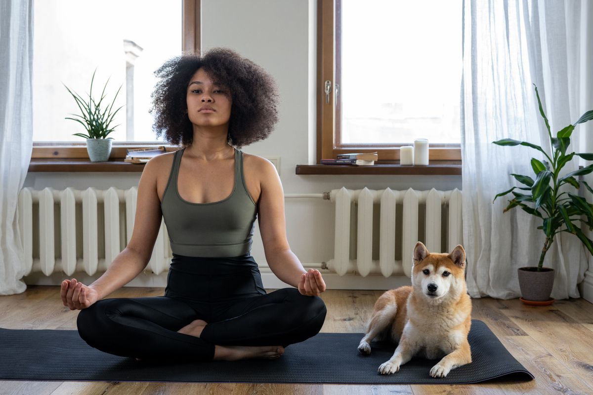 Instructor guiding an aerial hammock pose in a bright studio
